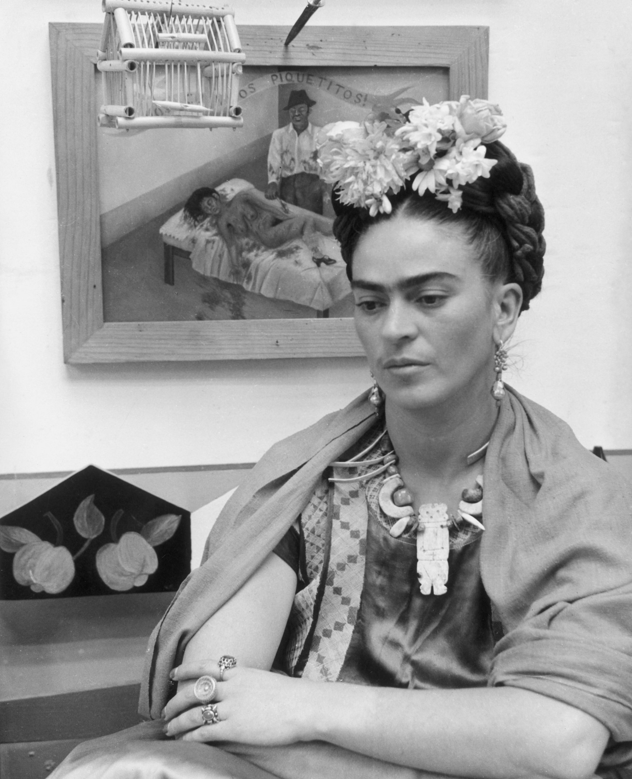 Frida Kahlo frente a su pintura "Unos cuantos piquetitos". / Hulton Archive, Getty Images